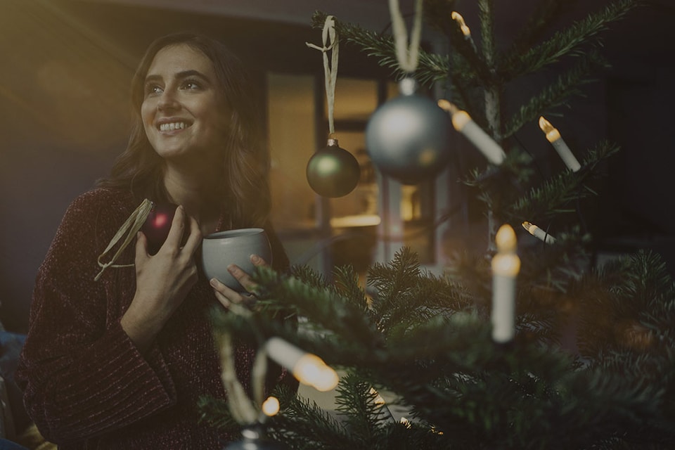 mujer viendo un árbol de navidad