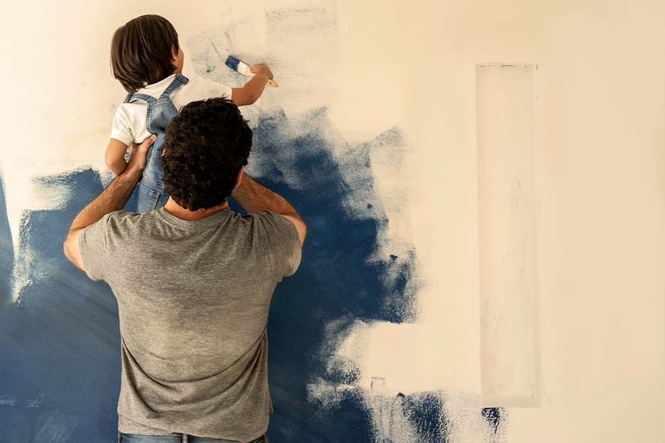 Padre e hijo pintando una pared