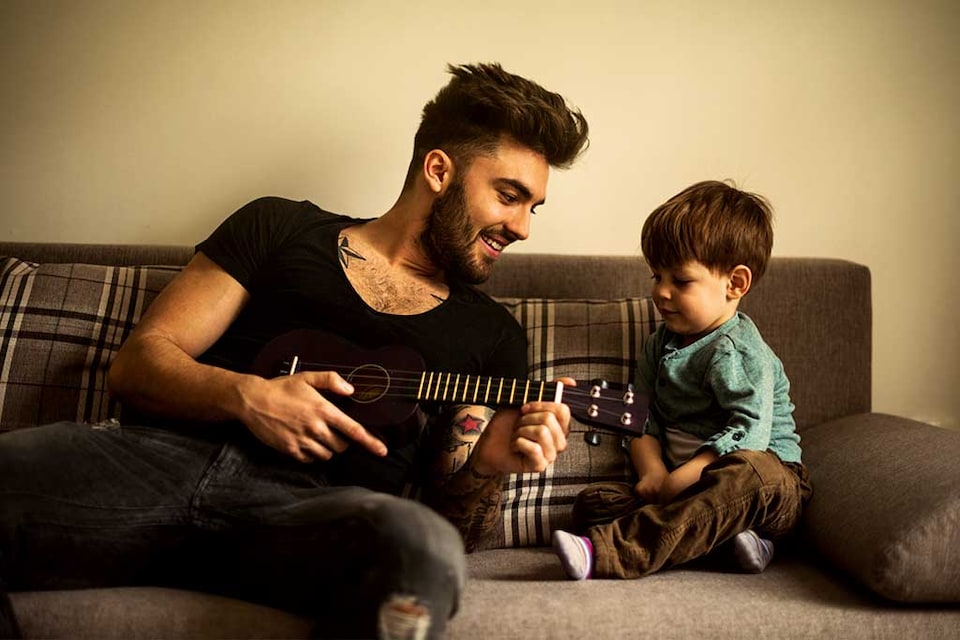 papá enseñando guitarra a su hijo