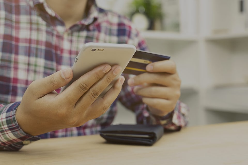 hombre sosteniendo una tarjeta de crédito 