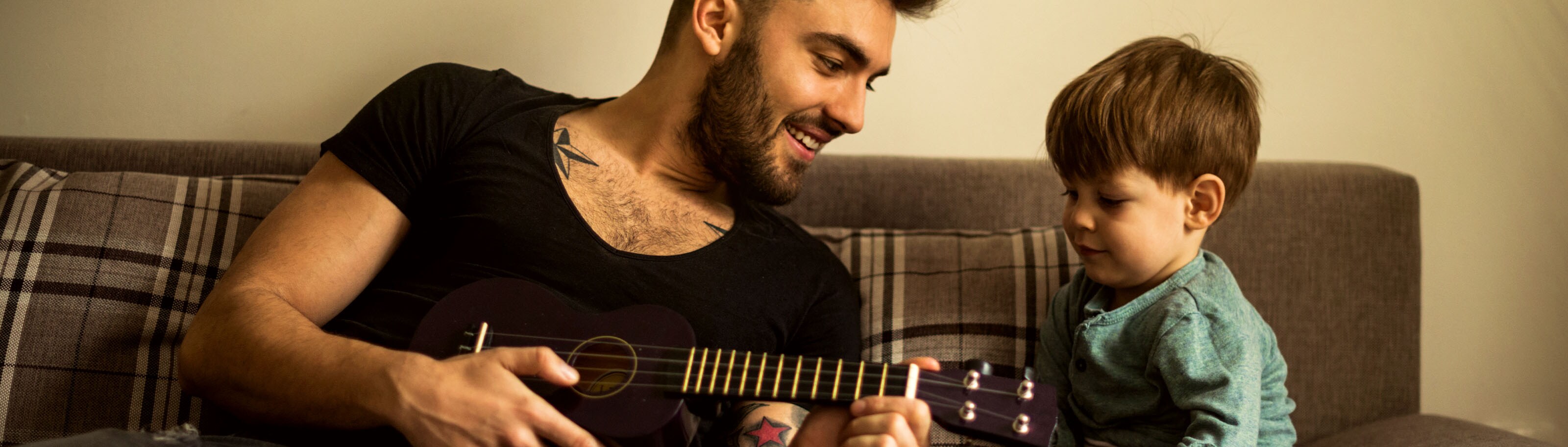 padre e hijo aprendiendo guitarra