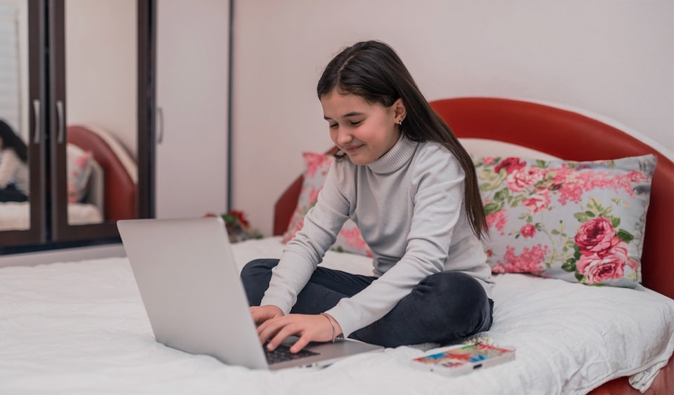 niña en su cuarto con laptop